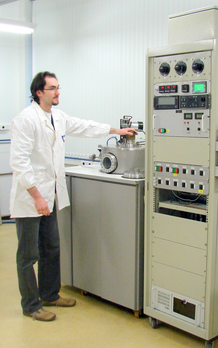 O doutorando César Aguzzoli no equipamento de magnetron sputtering. 