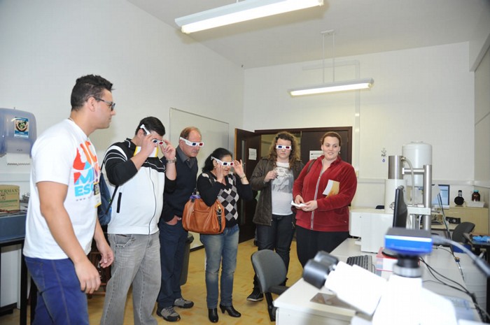 Visitantes com óculos para ver as imagens de microscopia em 3D. Foto: Claudia Velho. 